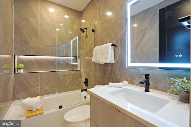 full bathroom with toilet, combined bath / shower with glass door, tasteful backsplash, tile walls, and vanity