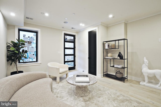 sitting room with light wood-style floors, baseboards, crown molding, and recessed lighting