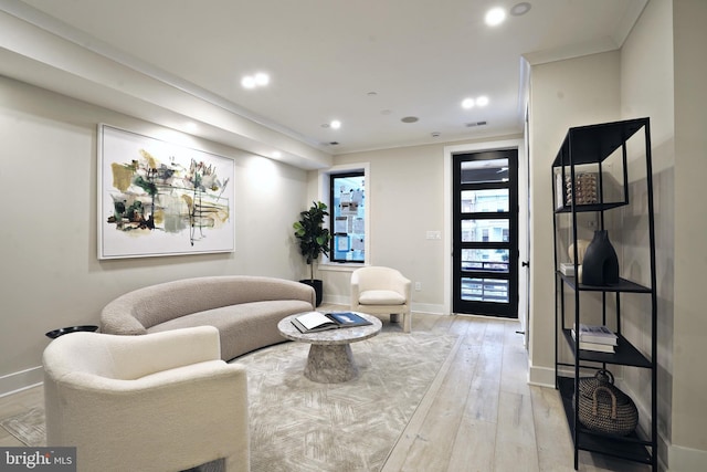 living room featuring ornamental molding and light hardwood / wood-style floors