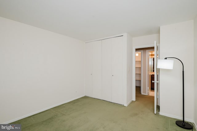 unfurnished bedroom featuring light colored carpet and a closet