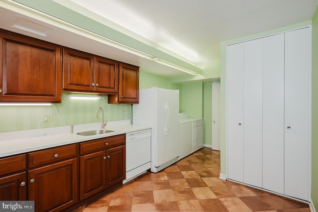 kitchen with sink, washer and dryer, and white appliances