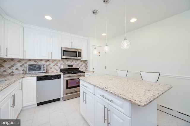 kitchen featuring stainless steel appliances, a baseboard radiator, white cabinetry, a kitchen island, and hanging light fixtures