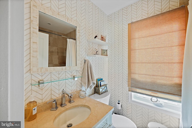 bathroom featuring walk in shower, vanity, and toilet