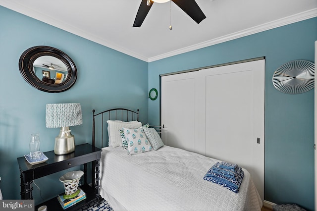 bedroom featuring ceiling fan, crown molding, and a closet