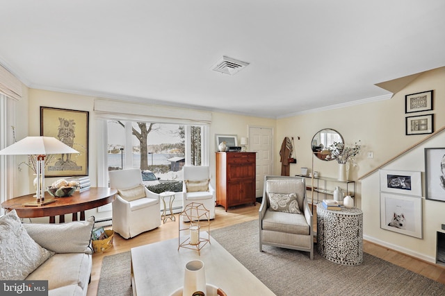 living room with crown molding, a baseboard radiator, and light wood-type flooring