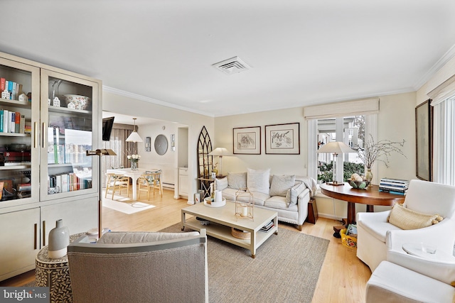 living room with light wood-type flooring and ornamental molding