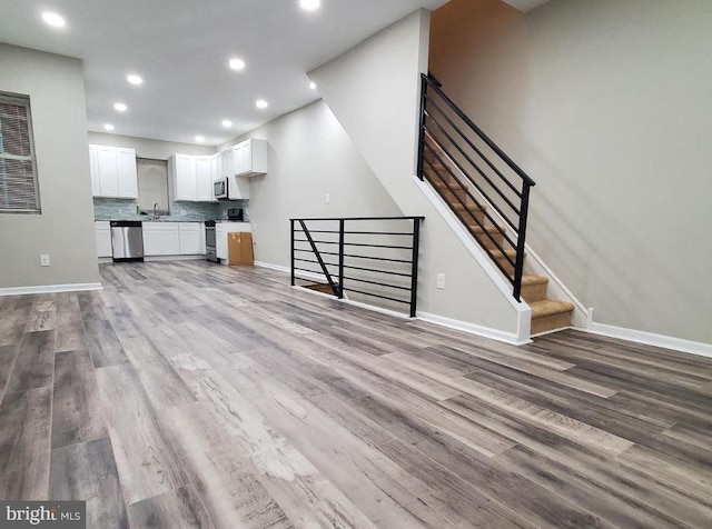 unfurnished living room with light hardwood / wood-style flooring and sink