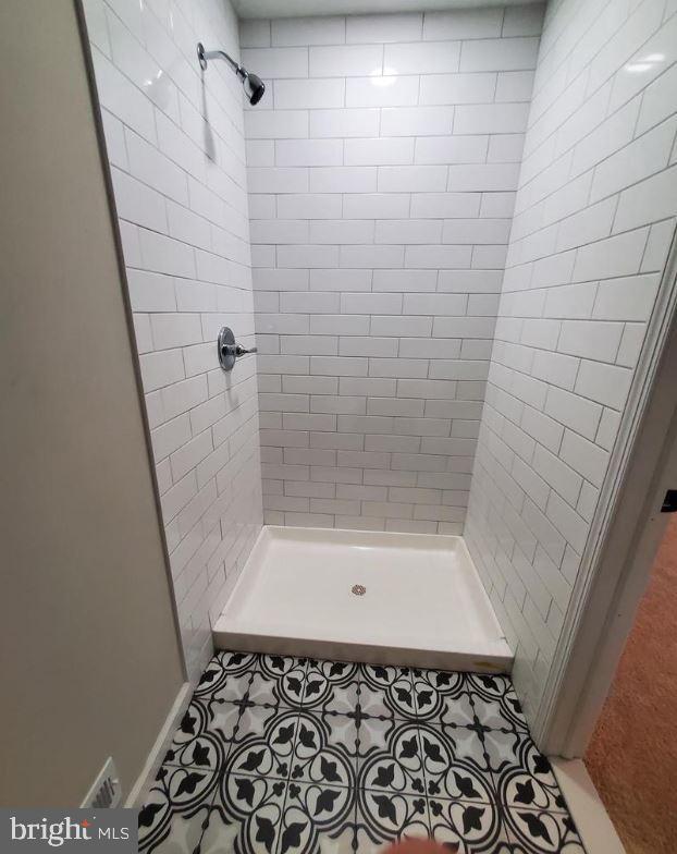 bathroom featuring a tile shower and tile patterned floors