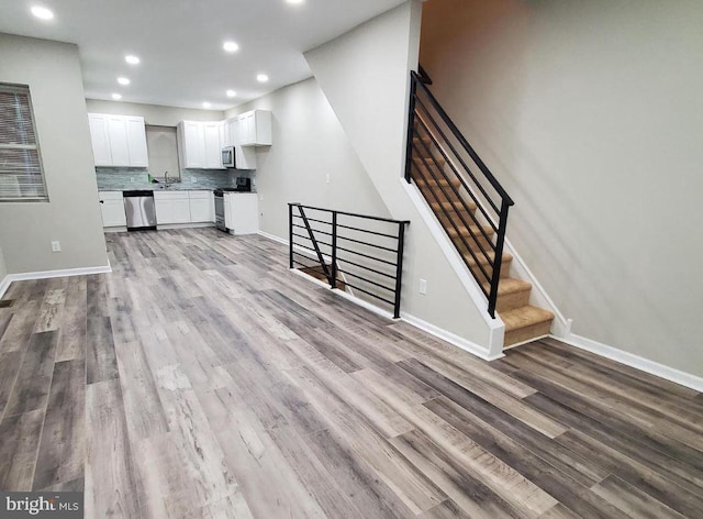 unfurnished living room featuring light hardwood / wood-style floors and sink