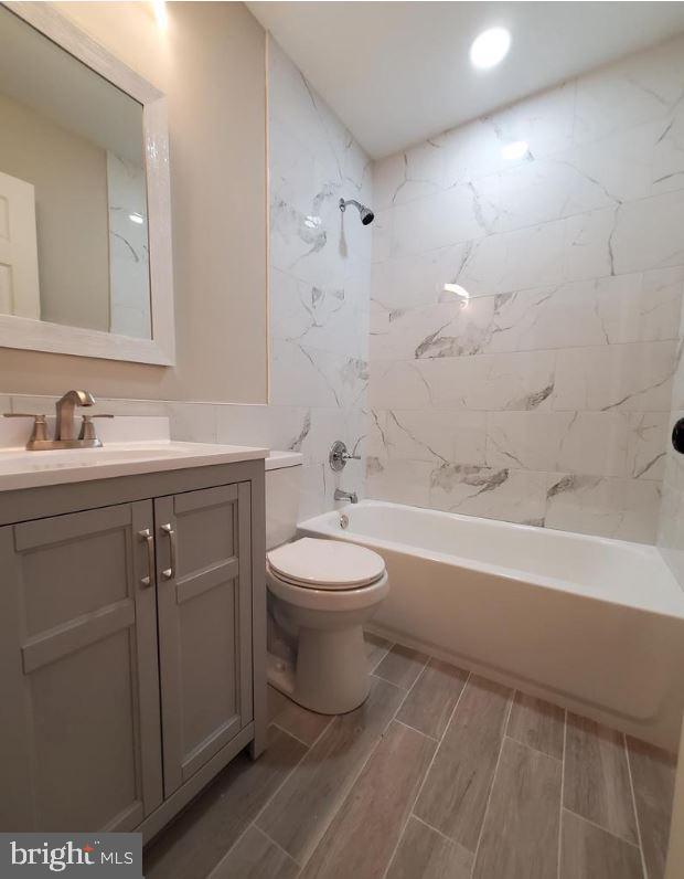 full bathroom with vanity, toilet, and tiled shower / bath