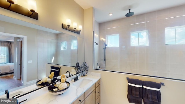 bathroom with hardwood / wood-style flooring, vanity, and a tile shower