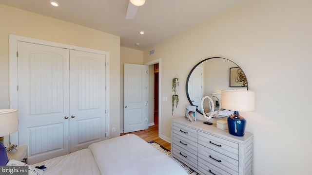 bedroom featuring ceiling fan, a closet, and light hardwood / wood-style floors