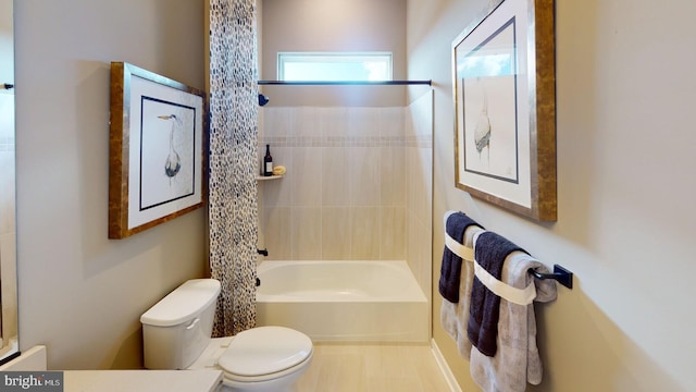 bathroom with toilet and tiled shower / bath