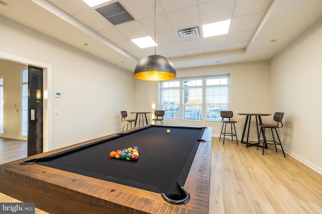 rec room with a paneled ceiling, light hardwood / wood-style floors, a raised ceiling, and pool table