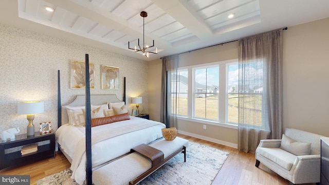 bedroom with beam ceiling, light hardwood / wood-style floors, and an inviting chandelier