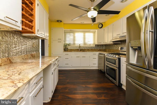 kitchen featuring white cabinetry, sink, light stone countertops, decorative backsplash, and appliances with stainless steel finishes