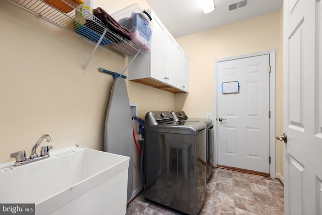 washroom with independent washer and dryer, cabinets, and sink