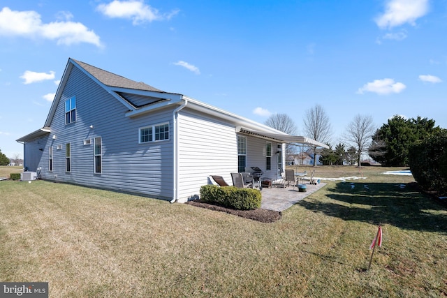 view of side of home with central AC, a yard, and a patio