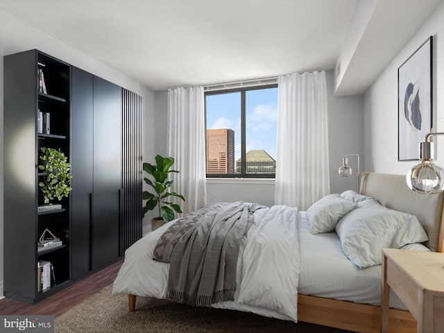 bedroom with dark wood-type flooring