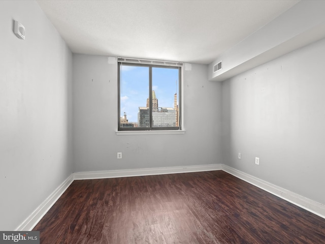 spare room with dark wood-type flooring