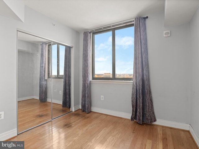 unfurnished bedroom featuring light wood-type flooring and a closet