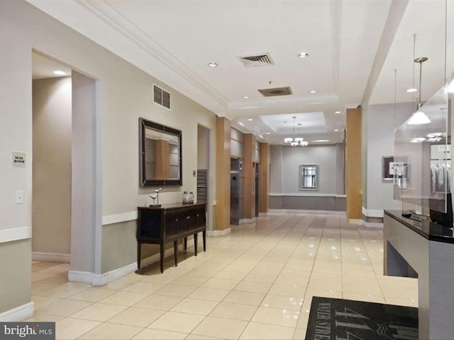 interior space featuring elevator, a raised ceiling, a notable chandelier, light tile patterned floors, and ornamental molding