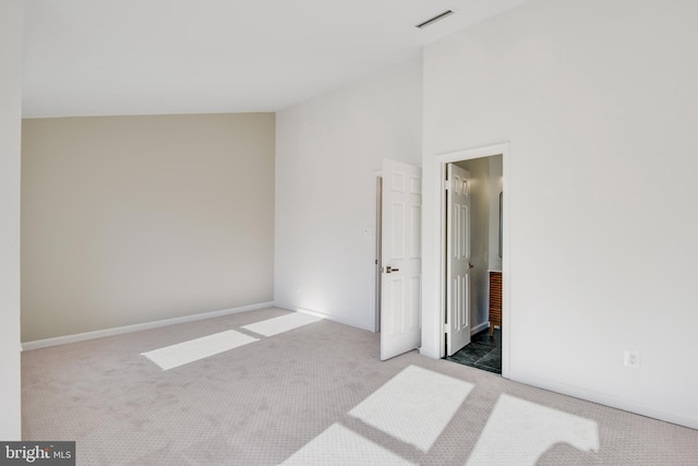 unfurnished bedroom with vaulted ceiling and carpet