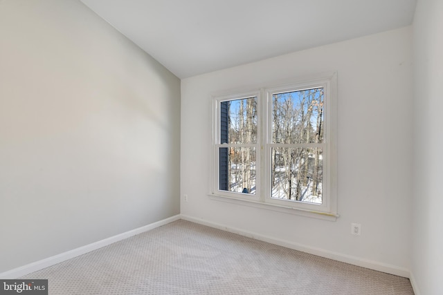 carpeted empty room featuring lofted ceiling