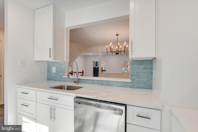 kitchen with white cabinets, light stone counters, sink, stainless steel dishwasher, and backsplash