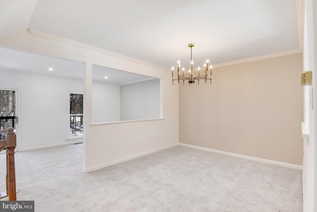 carpeted spare room featuring an inviting chandelier and ornamental molding