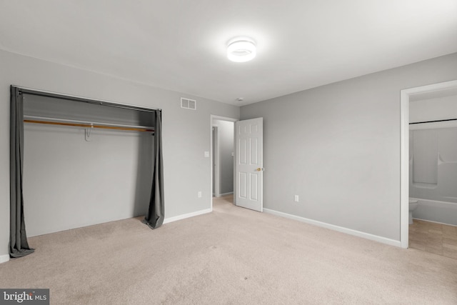 unfurnished bedroom with light carpet, baseboards, visible vents, and a closet