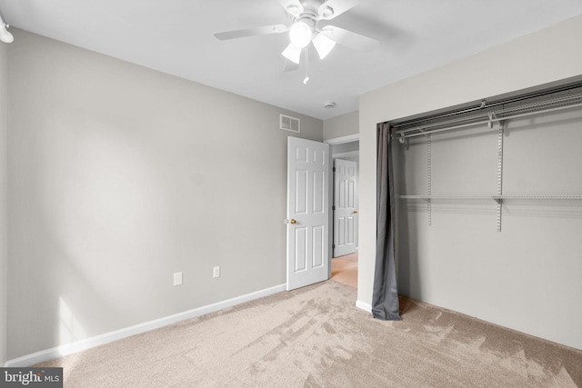 unfurnished bedroom with light colored carpet, visible vents, baseboards, a ceiling fan, and a closet