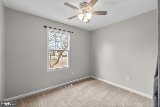 carpeted empty room featuring a ceiling fan, visible vents, and baseboards