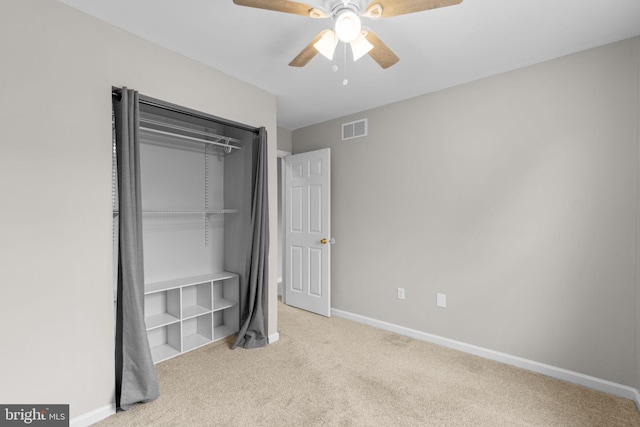 unfurnished bedroom with a closet, visible vents, light carpet, and baseboards