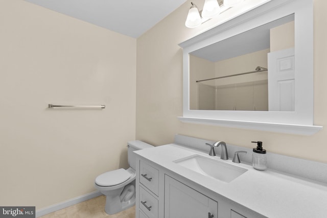 bathroom featuring toilet, baseboards, walk in shower, and vanity