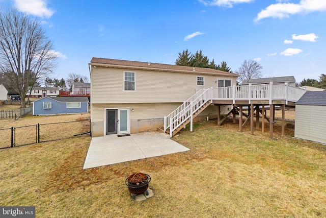 back of house with a lawn, fence, a fire pit, a wooden deck, and stairs