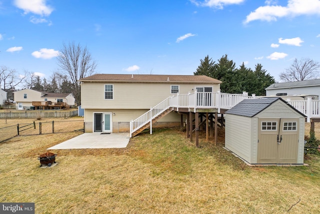 back of property with a storage shed, stairway, an outbuilding, a deck, and a yard