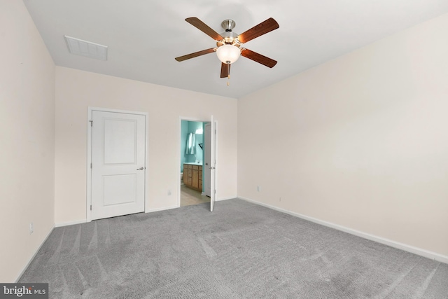 unfurnished bedroom featuring ceiling fan, light colored carpet, and connected bathroom