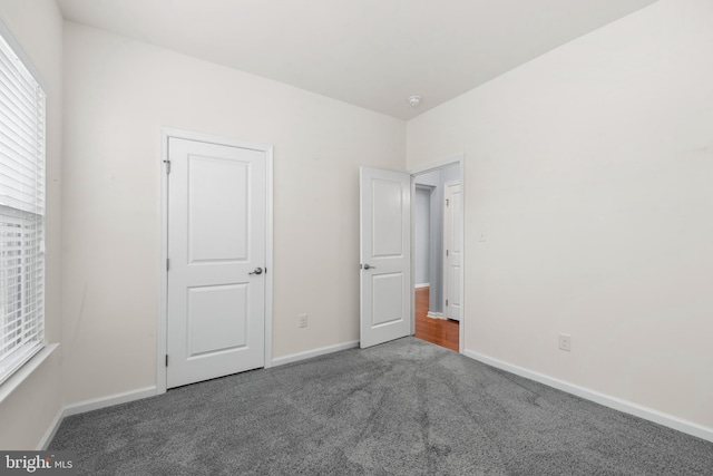 unfurnished bedroom featuring dark colored carpet