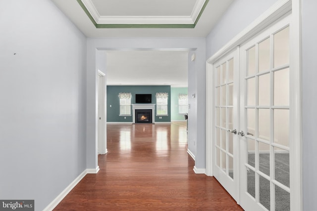 hallway with french doors, crown molding, and wood-type flooring