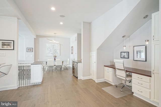 office space featuring beverage cooler, light hardwood / wood-style floors, and vaulted ceiling