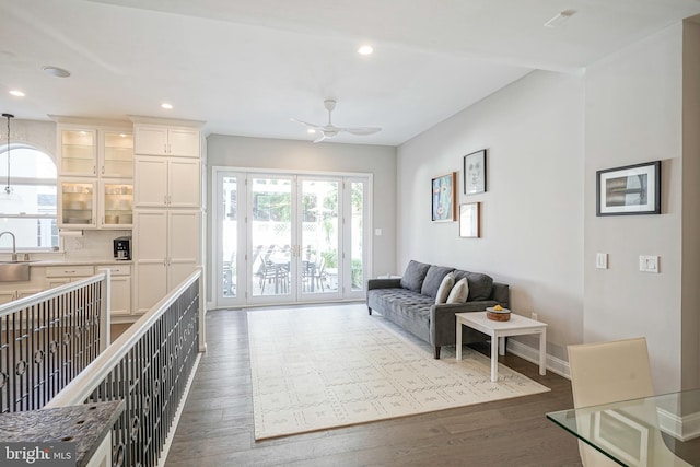 living room with hardwood / wood-style flooring, ceiling fan, and sink