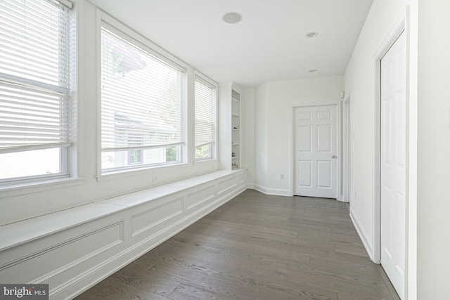 corridor with built in features and dark wood-type flooring