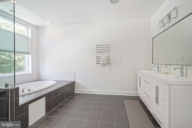 bathroom featuring tile patterned flooring, vanity, a relaxing tiled tub, and radiator