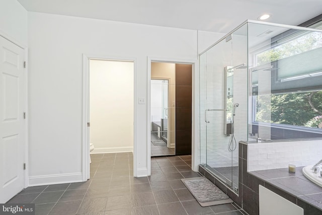 bathroom featuring tile patterned flooring, plus walk in shower, and toilet