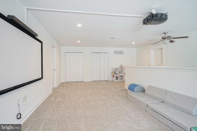 carpeted home theater room featuring ceiling fan