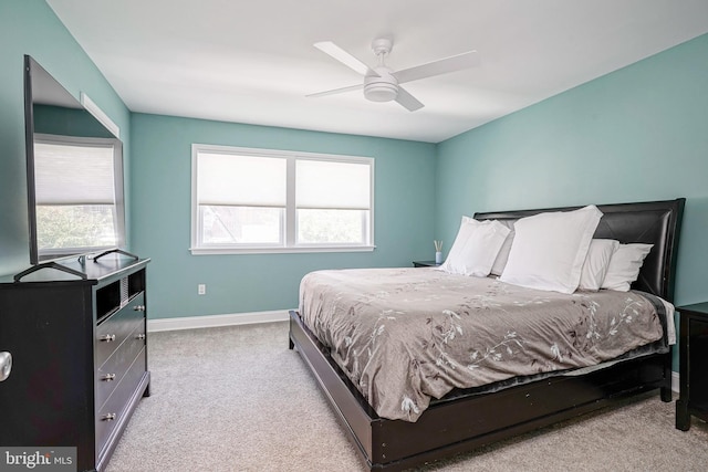 bedroom featuring ceiling fan, light colored carpet, and multiple windows