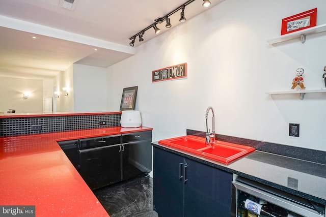 kitchen featuring dishwashing machine, rail lighting, and sink