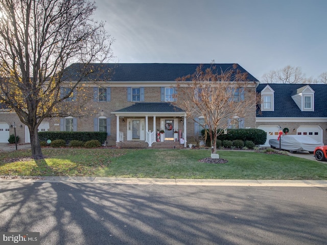 view of front facade with covered porch, a garage, and a front lawn