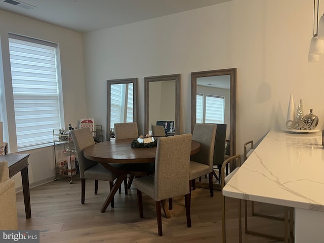 dining area featuring a wealth of natural light and light hardwood / wood-style flooring